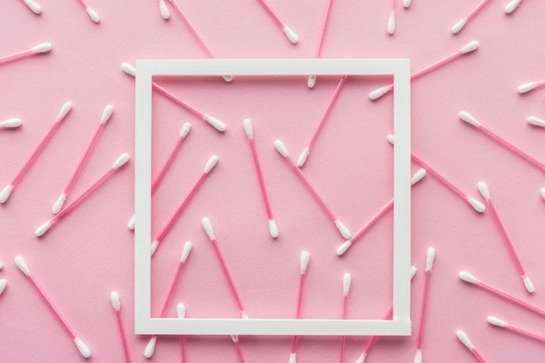 Ansicht von Wattestäbchen mit weißem Rahmen isoliert auf rosa, Schönheitskonzept — Stockfoto
