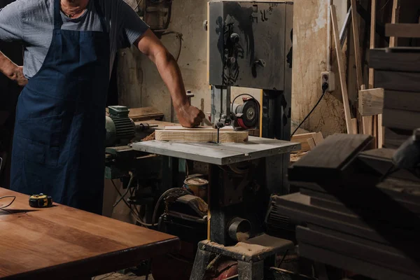 Vue partielle du menuisier debout près de la perceuse électrique à l'atelier en bois — Photo de stock