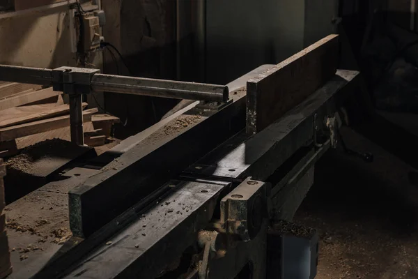 Закрытый обзор рабочего места деревообработчиков с оборудованием и древесиной в мастерской — стоковое фото