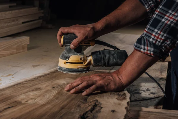 Partial view of carpenter working with electric plane at workshop — Stock Photo