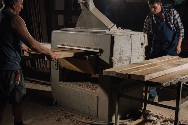 Menuisiers travaillant avec des planches en bois à l'atelier en bois — Photo de stock