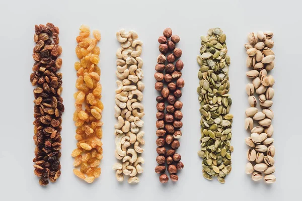 Surtido de deliciosas nueces y pasas aisladas sobre fondo blanco - foto de stock