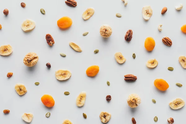 Vista superior de sabrosas frutas secas y frutos secos aislados sobre fondo blanco - foto de stock