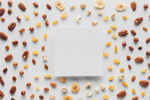 Flache Lage mit verschiedenen Trockenfrüchten und Nüssen mit Kopierraum in der Mitte isoliert auf weißem Hintergrund — Stockfoto