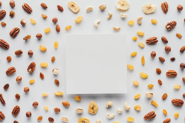 Flat lay with various dried fruits and nuts with copy space in center isolated on white background — Stock Photo