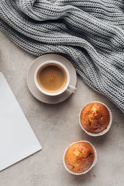 Top view of cup of coffee with muffins and blank paper on concrete surface — Stock Photo