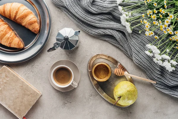 Draufsicht auf Tasse Kaffee mit Honig, Birne und Croissants auf Betonoberfläche — Stockfoto