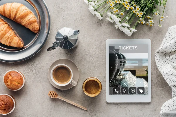 Vista dall'alto del caffè con pasticceria e tablet con app biglietti sullo schermo su superficie in cemento — Foto stock