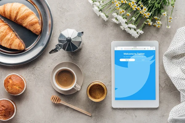 Vista superior de café com pastelaria e tablet com twitter site na tela na superfície de concreto — Fotografia de Stock