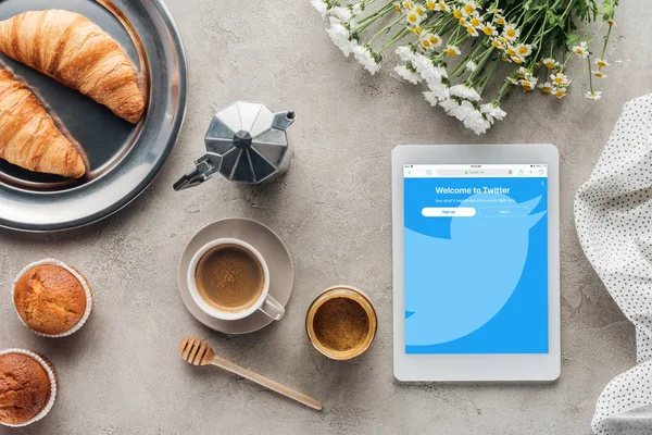 Вид зверху кави з тіста і таблетки з twitter сайт на екрані на бетонного покриття — стокове фото