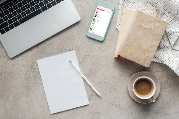 Vista superior de café com laptop e smartphone com aplicativo leitor de música na tela na superfície de concreto com papel em branco — Fotografia de Stock