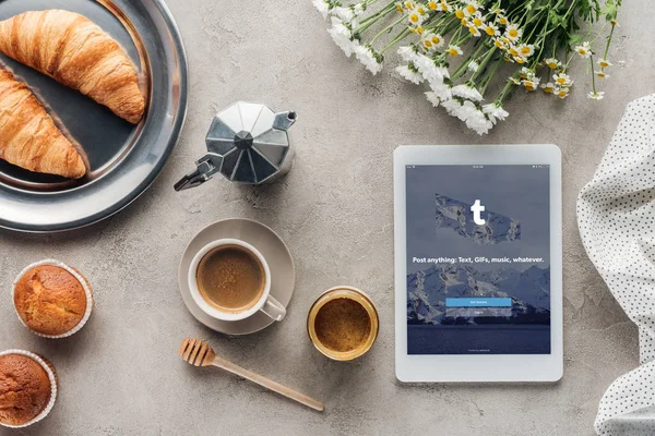 Vista superior de café com pastelaria e tablet com aplicativo tumblr na tela na superfície de concreto — Fotografia de Stock