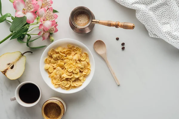 Vista superior de tigela de cereais com café e flores buquê em branco — Fotografia de Stock