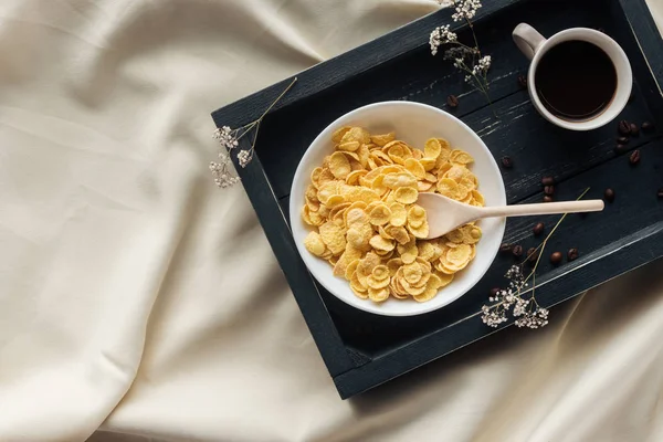Верхний вид на миску хлопьев завтрак с чашкой кофе на подносе на бежевой ткани, завтрак в кровать концепции — стоковое фото