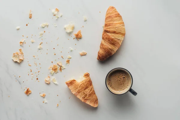 Vista dall'alto di tazzina di caffè e croissant su marmo bianco — Foto stock