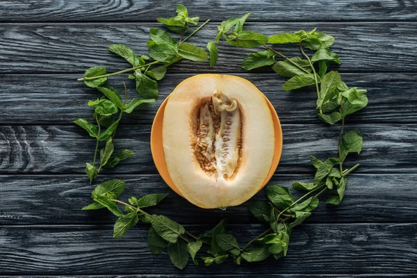 Vue de dessus du melon doux mûr frais et de la menthe fraîche sur la surface en bois — Photo de stock