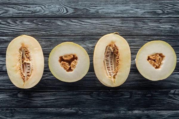 Vista dall'alto di meloni dolci maturi dimezzati su superficie di legno — Foto stock