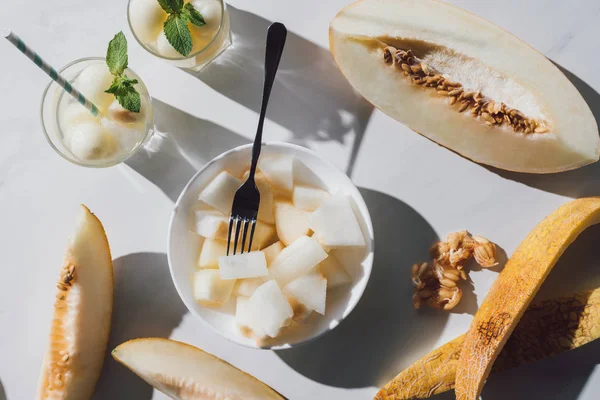 Blick von oben auf köstliche Melonenscheiben, Gläser mit Erfrischungsgetränk und Samen auf weißem Grund — Stockfoto