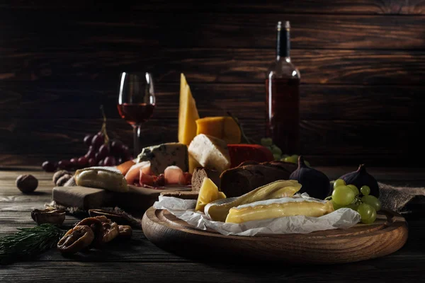 Different types of cheeses and fruits on cutting boards — Stock Photo