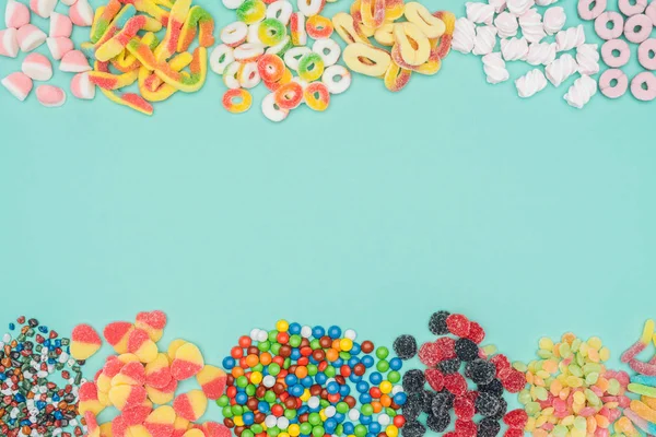 Top view of jelly candies, marshmallows and dragee isolated on turquoise — Stock Photo