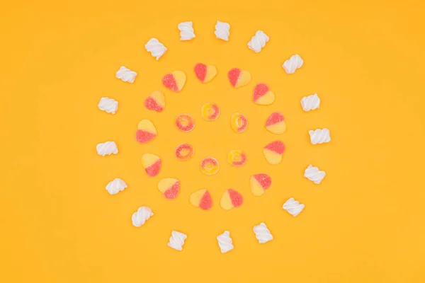 Top view of circles of delicious jelly candies and marshmallows isolated on orange — Stock Photo