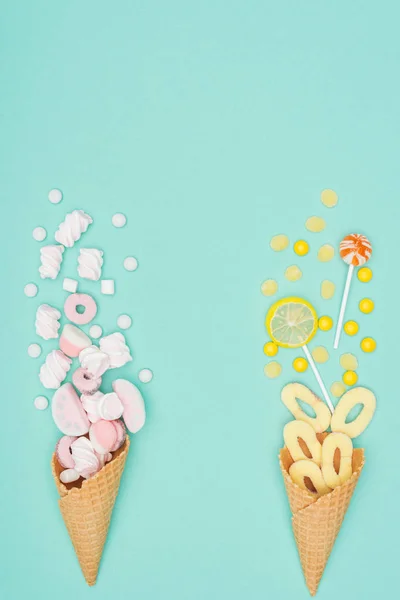 Top view of marshmallows, lollipops and waffle cones isolated on turquoise — Stock Photo