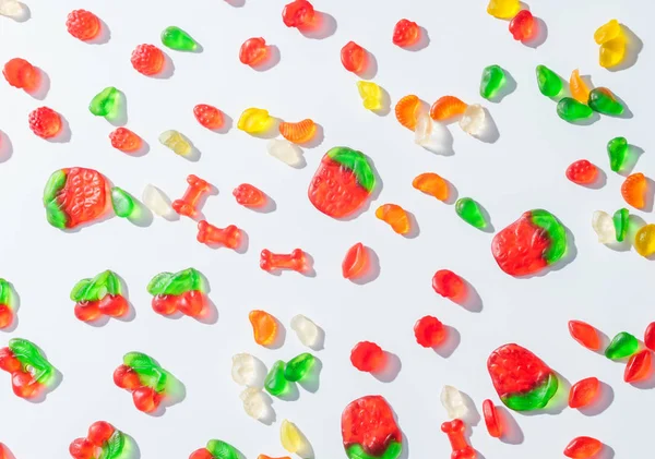 Elevated view of tasty scattered jelly candies on white — Stock Photo