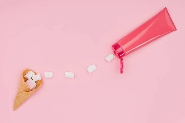 Vista dall'alto di marshmallow, cono di ghiaccio e tubo di plastica isolato su rosa — Foto stock