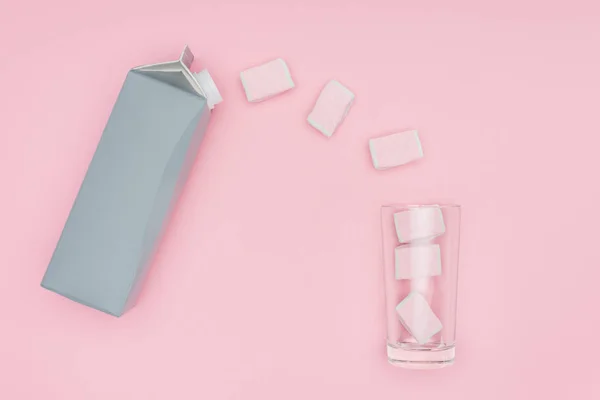 Ansicht von Marshmallows, Glas und Kartonverpackung isoliert auf rosa — Stockfoto