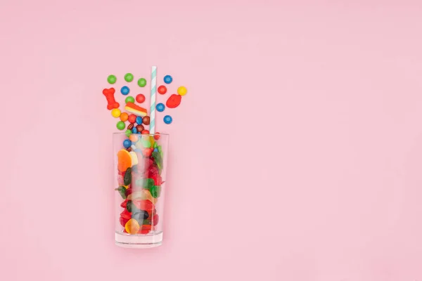 Top view of glass with jelly and dragee candies isolated on pink — Stock Photo