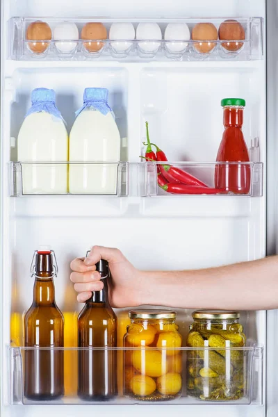 Immagine ritagliata dell'uomo che prende la bottiglia di birra dal frigorifero — Foto stock