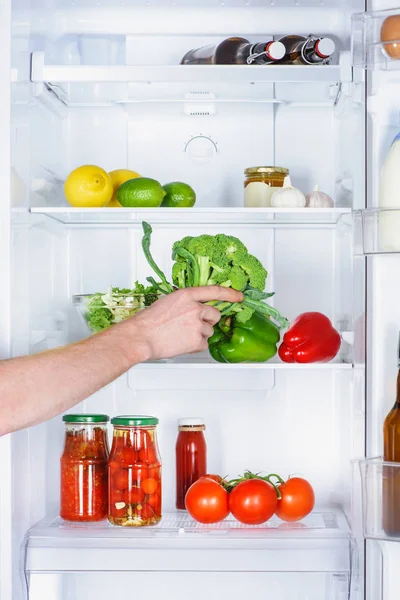 Imagem cortada do homem tomando brócolis da geladeira — Fotografia de Stock