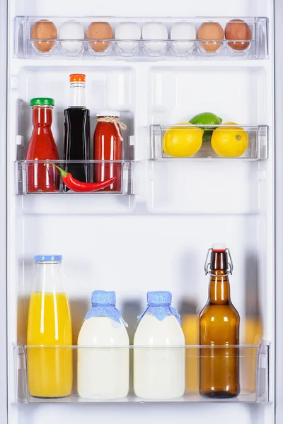 Uova, sposi, latte e succo di frutta in frigorifero — Foto stock
