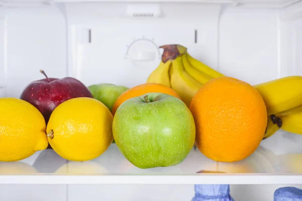 Perto de maçãs, laranjas e bananas na geladeira — Fotografia de Stock