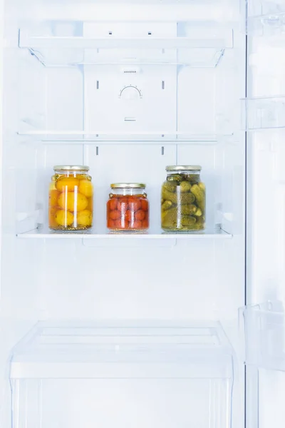 Conserves de légumes dans trois bocaux en verre au réfrigérateur — Photo de stock