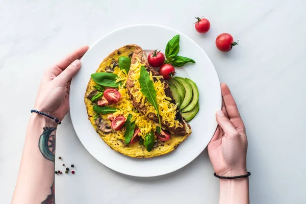 Partial view of woman at tabletop with homemade omelette for breakfast — Stock Photo