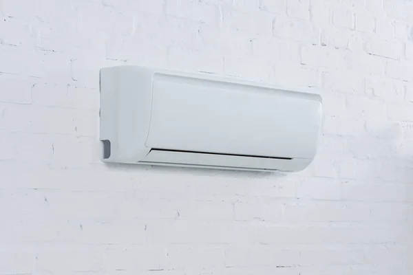 Nahaufnahme einer Klimaanlage, die an einer Ziegelwand hängt — Stockfoto