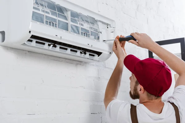 Nahaufnahme einer professionellen Reparaturfirma, die Filter für Klimaanlagen mit Schraubendreher austauscht — Stockfoto