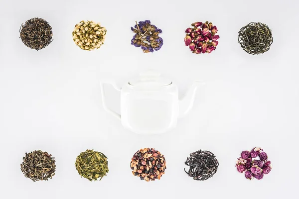 Vue de dessus de tisane séchée biologique et théière en verre isolé sur blanc — Photo de stock