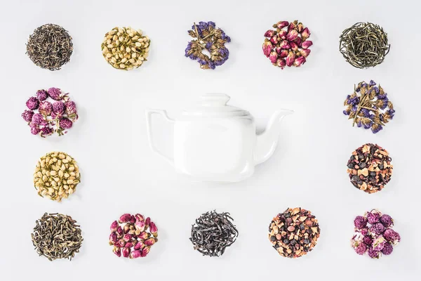 Erhöhte Ansicht der Teekanne im Rahmen von getrocknetem Bio-Kräutertee isoliert auf weiß — Stockfoto