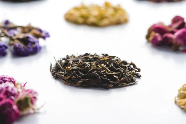 Colección de té seco a base de hierbas orgánicas en la mesa blanca - foto de stock