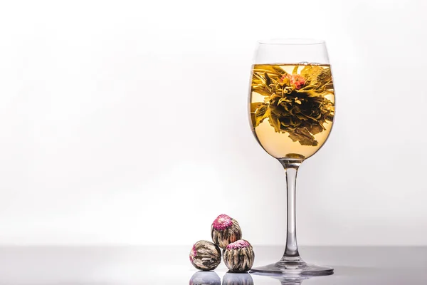 Vaso de té floreciente chino con bolas de té en la mesa - foto de stock