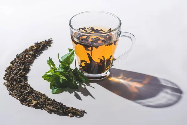 Чашка черного чая и мяты на белом столе — стоковое фото