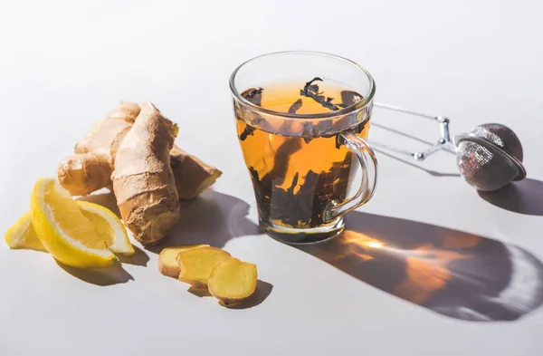 Black tea with lemon and ginger on white tabletop — Stock Photo