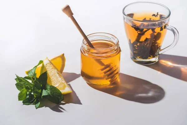 Tè sano con limone, menta e miele su un tavolo bianco — Foto stock