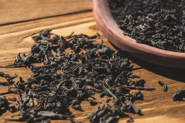 Ароматный сушеный черный чай на деревянном столе на кухне — стоковое фото