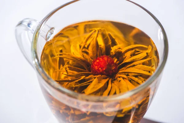 Primer plano de té de hierbas con flor en vidrio - foto de stock