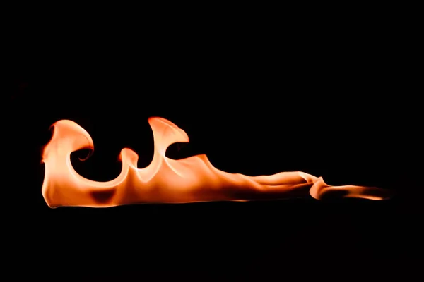 Close up view of burning orange fire on black background — Stock Photo