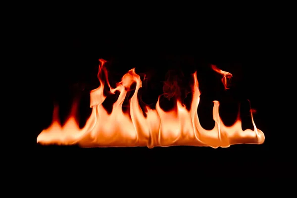 Vista da vicino di bruciare fuoco arancione su sfondo nero — Foto stock