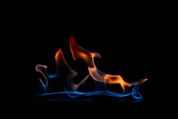 Nahaufnahme der brennenden orangen und blauen Flamme auf schwarzem Hintergrund — Stockfoto